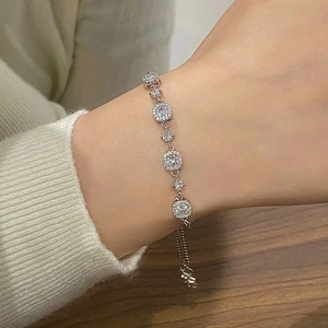 Sparkling zircon silver bracelet with adjustable chain worn against a cozy knit sleeve
