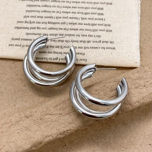 Minimalist silver triple-layered metal hoop earrings with a polished industrial finish