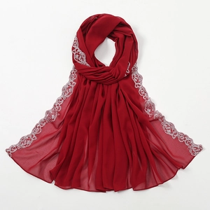 Detailansicht eines dunkelroten Chiffon-Kopftuchs mit weißer floraler Spitzenbestickung