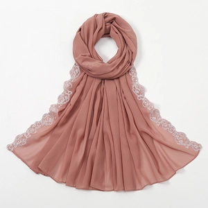 Detail eines weichen Chiffon-Hijabs mit weißem Blumen-Spitzenbesatz in Ziegelrot