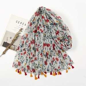 Detail of ethnic floral print scarf with delicate tassels and bohemian aesthetic layout
