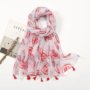 Detailed view of lightweight boho scarf with red feather prints and fringe edges