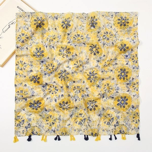 Detailed flat lay of ethnic print scarf with vibrant yellow and blue floral patterns