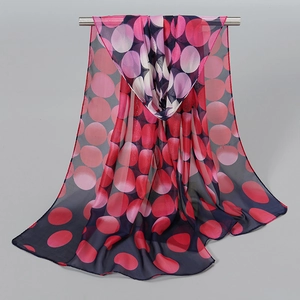 Detail of dark blue chiffon scarf with red and pink gradient polka dots hanging on a bar