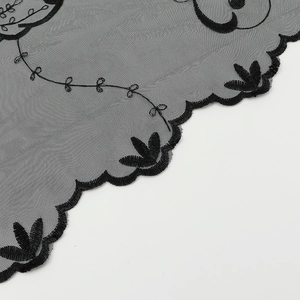 Gros plan détaillé d'une broderie de dentelle noire avec des motifs de bordure festonnée