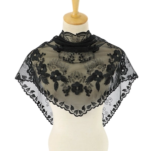 Vue détaillée des broderies florales noires sur le châle triangulaire en dentelle transparente