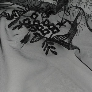 Close-up of black floral lace embroidery detail on breathable mesh triangle scarf