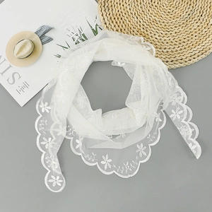 Detail of white embroidered lace scarf with scalloped edges and floral mesh pattern