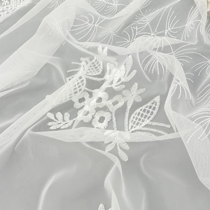 Close-up of elegant white floral embroidery on premium breathable lace mesh fabric