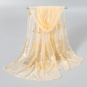 Close-up of lightweight champagne scarf with golden peacock feather print detail