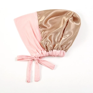 Dettaglio della cuffia da notte bicolore rosa e oro con elastico e nastrini