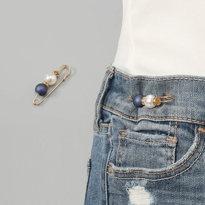 Pearl rhinestone safety pin waist tightening brooch detail showing practical clothing decoration use.