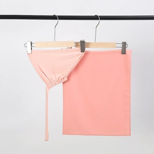 Detail of light pink chiffon hijab and matching undercap set on a wooden hanger
