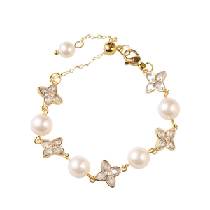 Elegant gold pearl bracelet featuring sparkling zircon four-leaf flower charms and lobster clasp