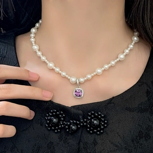 Détail d'un collier de perles avec pendentif en pierre violette carrée et zircons