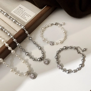 Détail d'un collier de perles élégant et d'un bracelet avec cristal carré au centre