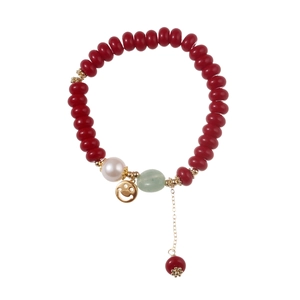 Red beaded bracelet with pearl, green stone bead and golden smiley face charm pendant