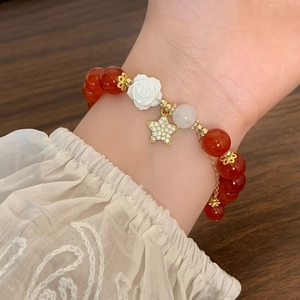 Vintage Perlenarmband aus rotem Achat mit Kamelienblüte und Zirkonstern am Handgelenk