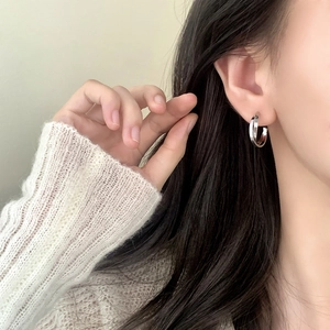 Boucles d'oreilles doubles cercles entrelacés en argent portées pour un style moderne