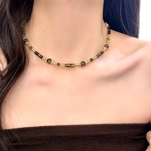 Collana di perle occhio di tigre stile Maillard con accenti dorati indossata da una modella
