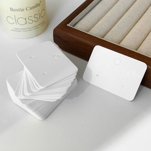 Stack of white premium cardboard jewelry display cards with hanging holes for earrings