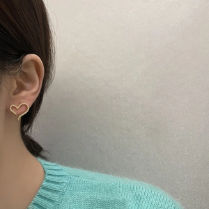 Elegant gold heart stud earrings with sparkling cubic zirconia shown on model