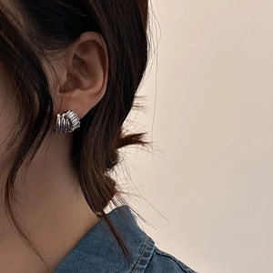 Minimalist silver twist stud earrings with rectangular zircon stones on model's ear