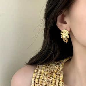 Elegant gold woven leaf earrings for women featuring a textured fan-shaped metal design
