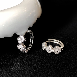 Vue macro de boucles d'oreilles trèfle en argent ornées de pierres de zircone cubique