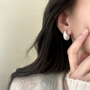 Silver teardrop earrings with metallic woven texture on model for a minimalist style