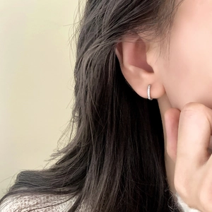 Boucles d'oreilles créoles argentées avec pavé de zircons portées par un mannequin en gros plan