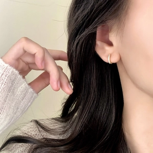 Élégantes créoles plaquées or 18 carats avec zircons portées par un mannequin