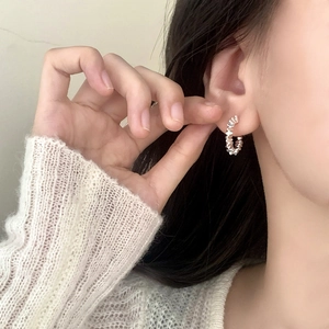 Silver C-shape hoop earrings with twisted texture worn by model for a stylish look