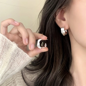 Minimalist silver hoop earrings featuring irregular textured liquid metal design style