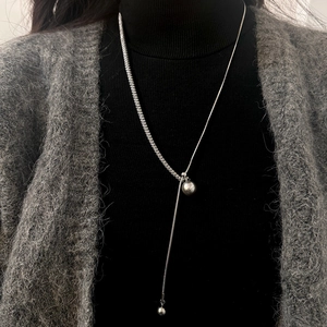 Silver Y-shaped lariat necklace with pearl detail and CZ accents on black sweater
