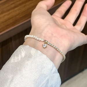 Elegant French pearl and sparkling zircon bracelet with round crystal charm on wrist