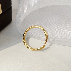 Vue détaillée d'une bague dorée ajustable avec une texture de lave liquide