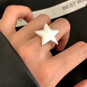 Bague étoile ouverte en argent avec texture brossée mate portée par un modèle