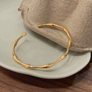 Bamboo style open bracelet in gold-plated brass with a minimalist geometric texture