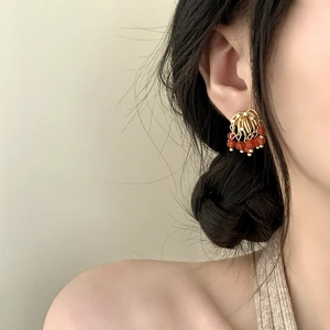 Elegant red agate tassel earrings with zircon fireworks design on a model's ear