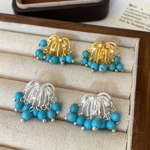 Detail of luxury firework tassel earrings with zircon studs in gold and silver plating
