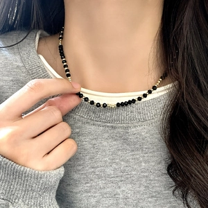 French vintage black crystal beaded necklace with gold accents worn by a model