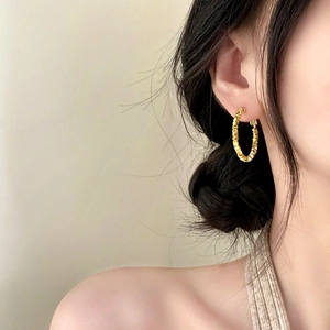Irregular textured gold hoop earrings for women shown on model for stylish look