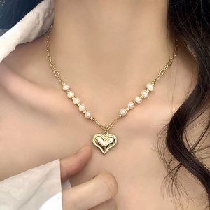 French style gold heart pendant necklace with freshwater pearls shown on a model neck