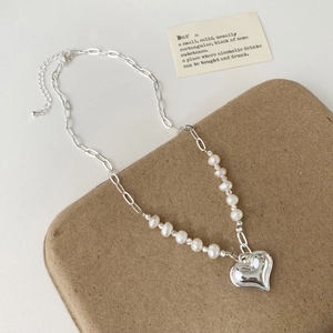Close-up of paperclip chain necklace with freshwater pearls and silver heart pendant