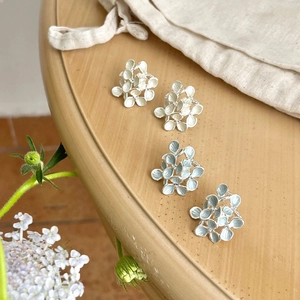 Macro view of French vintage floral stud earrings in white and light blue enamel finish