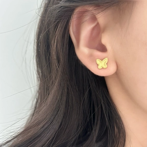 Elegant matte gold butterfly stud earrings worn by a model for a chic and stylish look