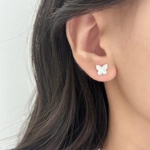 Delicate silver butterfly stud earrings with pavé crystals shown on ear for women