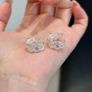Chic silver heart drop earrings with hollow weave texture held in hand for daily style