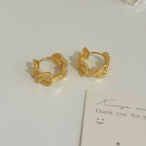 Detail view of gold-plated hollow heart earrings with vintage textured weave design